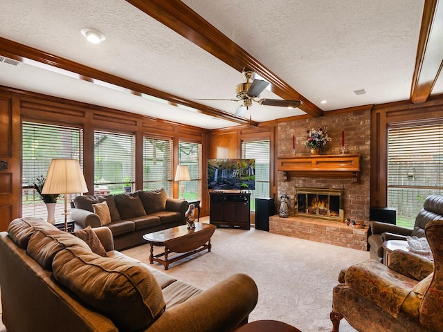 16707 Rugby Ct, Spring, TX 77379 - carpeted living area with a textured ceiling, beamed ceiling, ceiling fan, and a fireplace