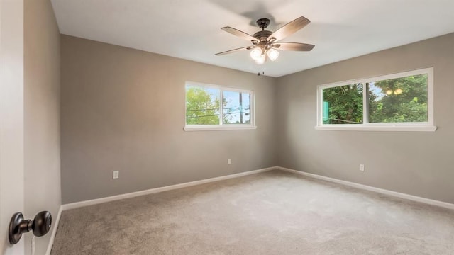 unfurnished room featuring a ceiling fan, baseboards, and light colored carpet