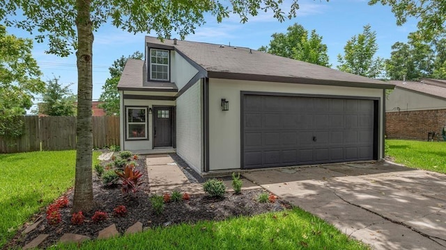 view of front of house featuring a front yard, an attached garage, and fence