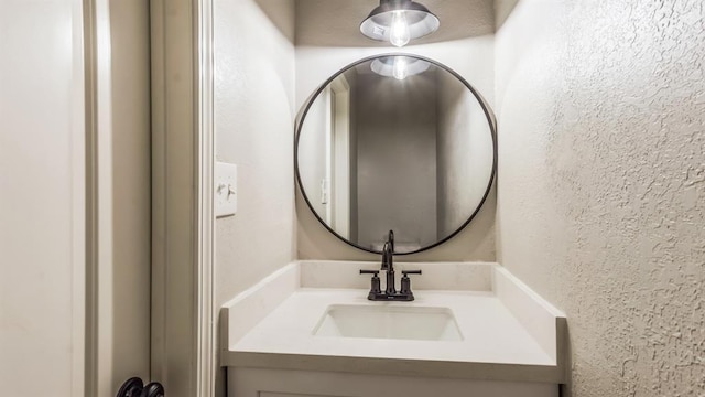 bathroom with vanity and a textured wall