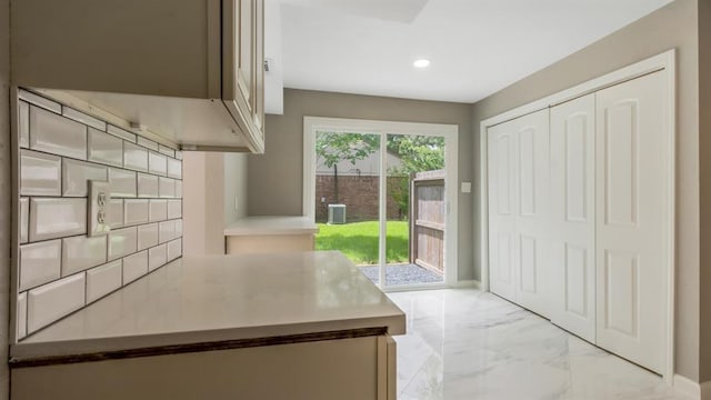 kitchen with baseboards, marble finish floor, light countertops, and recessed lighting