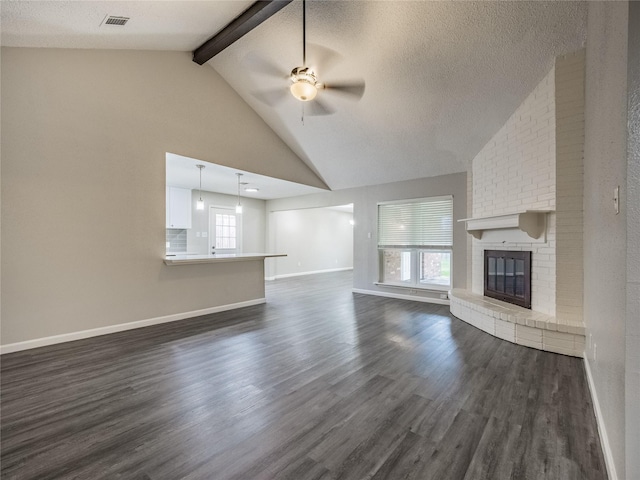 1701 N Park Way Dr, Deer Park, TX 77536 - unfurnished living room featuring ceiling fan, dark wood-type flooring, healthy amount of natural light, a fireplace, and beamed ceiling