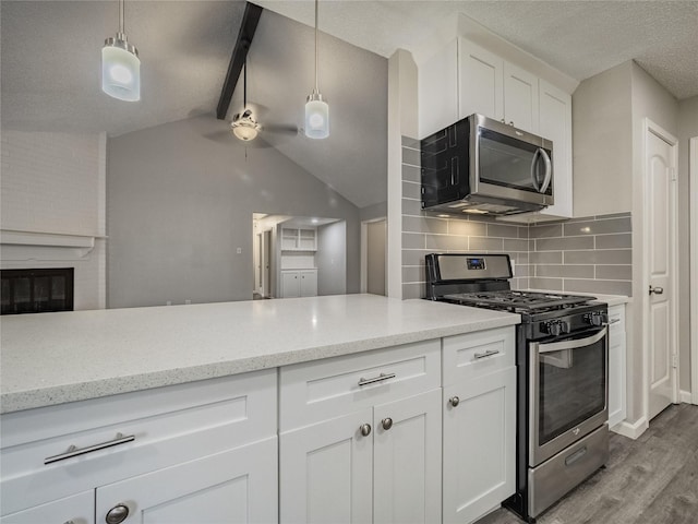 1701 N Park Way Dr, Deer Park, TX 77536 - kitchen featuring stainless steel appliances, wood finished floors, white cabinetry, a ceiling fan, and light stone counters