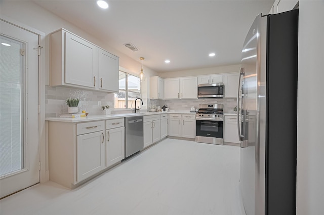 5615 Haven Point Dr, Houston, TX 77084 - kitchen featuring a sink, white cabinetry, visible vents, appliances with stainless steel finishes, and decorative backsplash