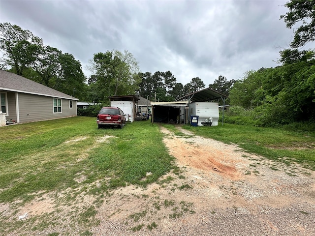 11480 Persimmon St, Willis, TX 77318 - view of grassy yard featuring driveway and a detached carport