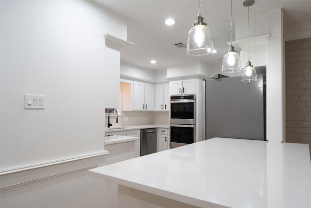18007 Ravenfield Dr, Houston, TX 77084 - kitchen featuring light countertops, a sink, white cabinets, stainless steel appliances, and decorative light fixtures