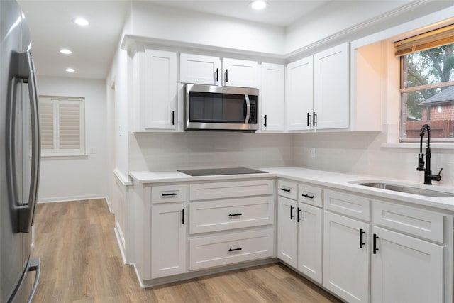 18007 Ravenfield Dr, Houston, TX 77084 - kitchen featuring a sink, appliances with stainless steel finishes, light wood finished floors, and decorative backsplash