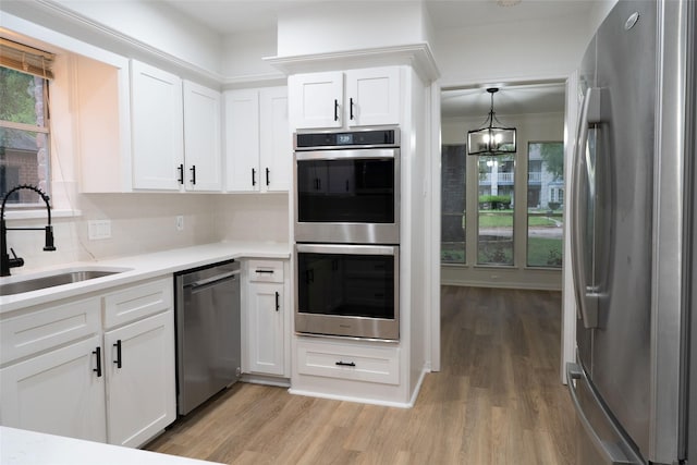 18007 Ravenfield Dr, Houston, TX 77084 - kitchen featuring decorative backsplash, light wood-style flooring, a sink, and appliances with stainless steel finishes