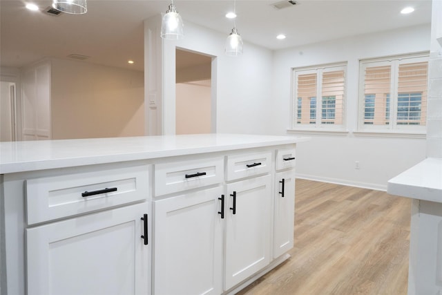 18007 Ravenfield Dr, Houston, TX 77084 - kitchen featuring white cabinetry, light countertops, decorative light fixtures, visible vents, and light wood-style flooring
