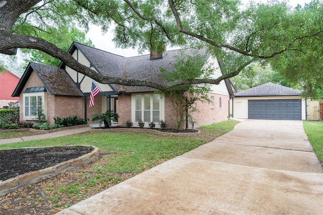 18007 Ravenfield Dr, Houston, TX 77084 - view of front of house with an outdoor structure, a front lawn, brick siding, a shingled roof, and a chimney