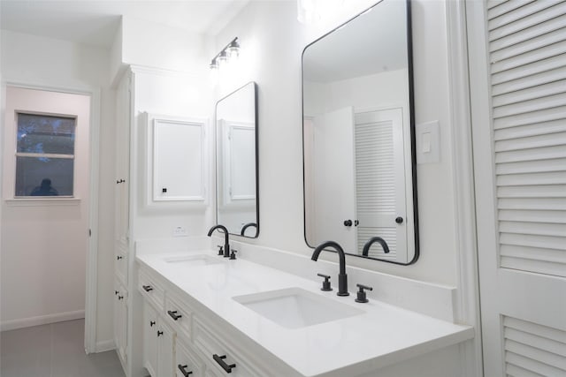18007 Ravenfield Dr, Houston, TX 77084 - bathroom featuring double vanity, baseboards, a sink, and tile patterned floors