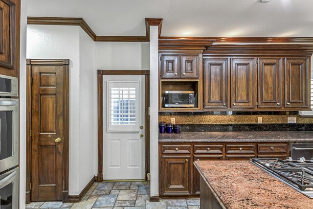 2926 Deer Creek Dr, Sugar Land, TX 77478 - kitchen featuring stone tile flooring, baseboards, appliances with stainless steel finishes, dark stone countertops, and backsplash