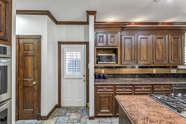 2926 Deer Creek Dr, Sugar Land, TX 77478 - kitchen with stone tile floors, baseboards, gas cooktop, stainless steel microwave, and dark stone counters
