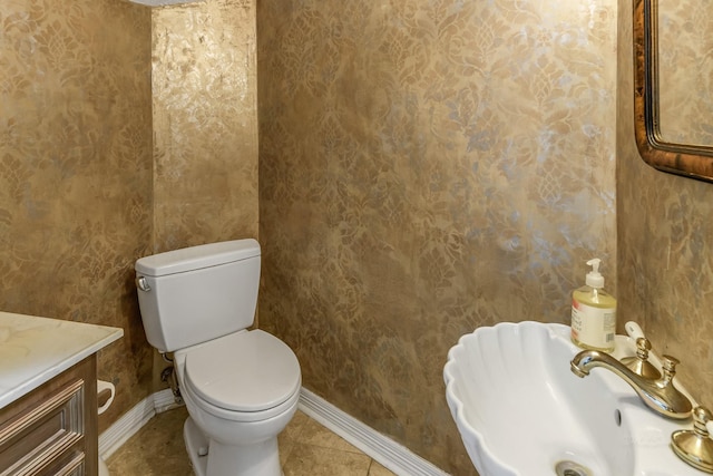 2926 Deer Creek Dr, Sugar Land, TX 77478 - half bath with baseboards, toilet, tile patterned floors, wallpapered walls, and vanity