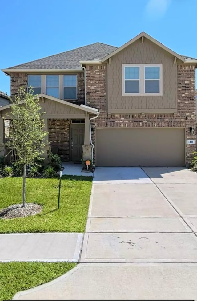 5114 Monarch Belle Ln, Katy, TX 77493 - view of front of house with brick siding, an attached garage, a front lawn, and concrete driveway