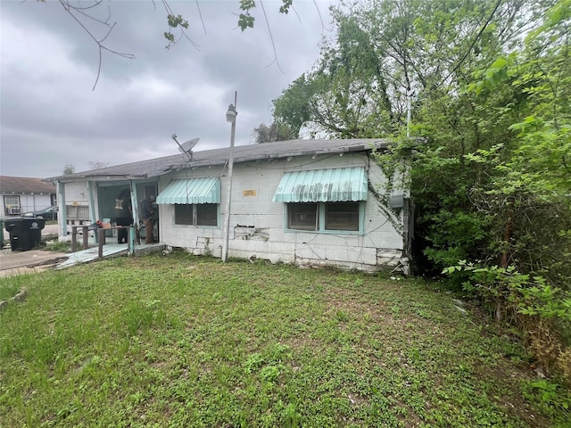 rear view of property featuring a patio and a lawn