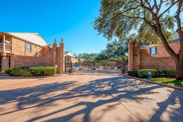 2255 Braeswood Park Dr Unit 294, Houston, TX 77030 - view of concrete road with a gate, curbs, and a gated entry
