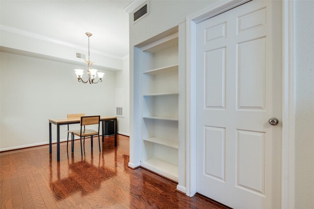 2255 Braeswood Park Dr Unit 294, Houston, TX 77030 - unfurnished dining area featuring built in shelves, ornamental molding, dark wood-style floors, a chandelier, and baseboards