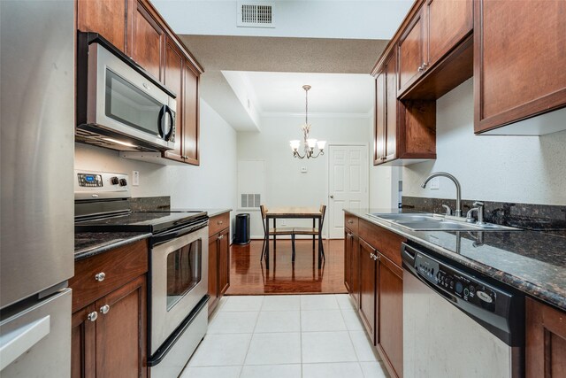 2255 Braeswood Park Dr Unit 294, Houston, TX 77030 - kitchen with appliances with stainless steel finishes, a sink, a chandelier, crown molding, and hanging light fixtures