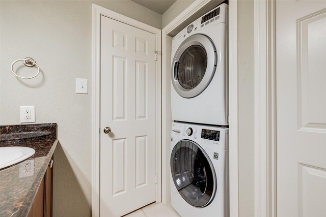 2255 Braeswood Park Dr Unit 294, Houston, TX 77030 - laundry area with stacked washing machine and dryer and light tile patterned flooring