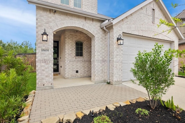 15039 Eves Necklace Ct, Cypress, TX 77433 - view of exterior entry with brick siding, an attached garage, and fence