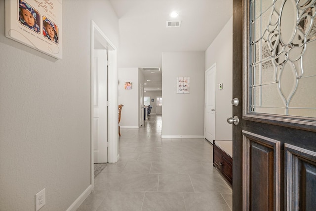 entrance foyer featuring light tile patterned flooring, visible vents, and baseboards