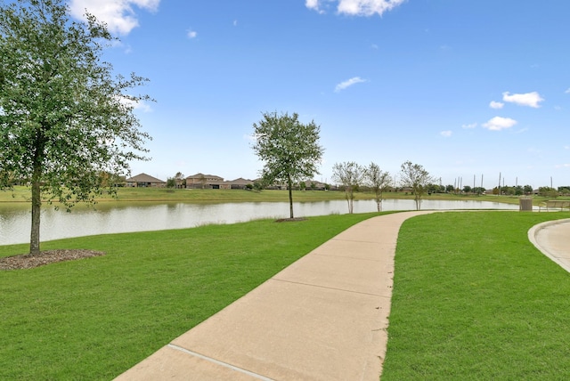 surrounding community with a lawn and a water view