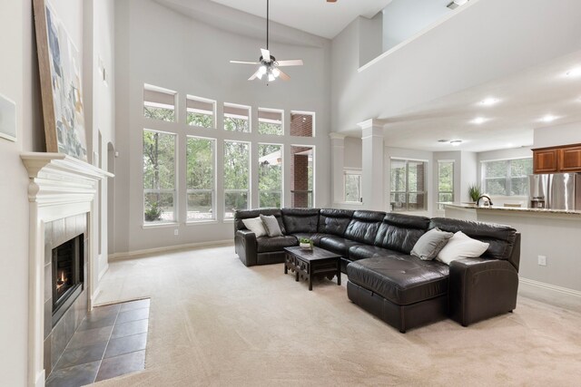 4911 Ontonagon Way, Spring, TX 77386 - living room featuring light carpet, a ceiling fan, a high ceiling, a tile fireplace, and baseboards