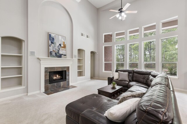 4911 Ontonagon Way, Spring, TX 77386 - carpeted living room featuring built in shelves, a towering ceiling, a ceiling fan, and healthy amount of natural light