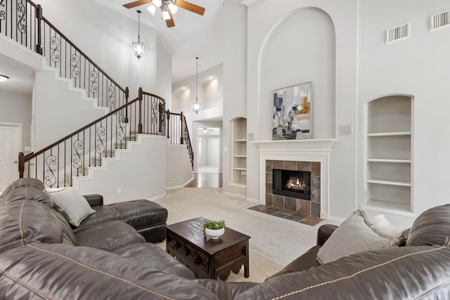 living area with visible vents, a ceiling fan, built in shelves, and carpet