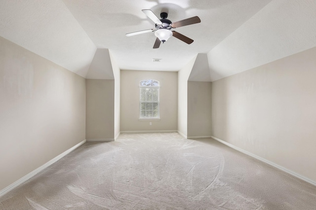 bonus room with carpet floors, baseboards, lofted ceiling, and ceiling fan