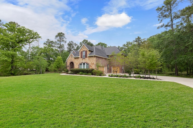 view of front of house featuring a front yard, stone siding, brick siding, and concrete driveway