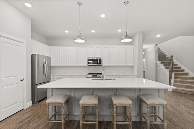kitchen with decorative backsplash, a sink, recessed lighting, and appliances with stainless steel finishes