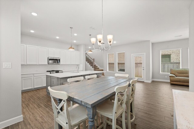 dining space with baseboards, recessed lighting, a chandelier, and dark wood finished floors