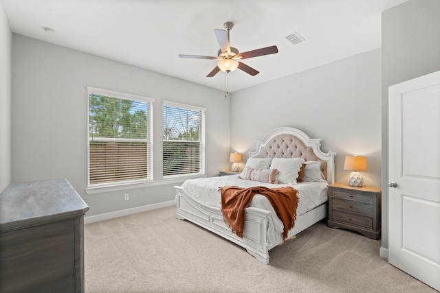 bedroom with ceiling fan, light carpet, visible vents, and baseboards