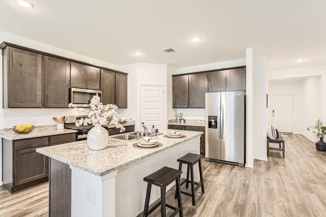 25617 Microstar Way, Montgomery, TX 77316 - kitchen with appliances with stainless steel finishes, a sink, dark brown cabinets, light wood-style flooring, and recessed lighting