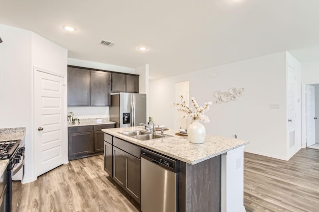 25617 Microstar Way, Montgomery, TX 77316 - kitchen featuring stainless steel appliances, a sink, dark brown cabinetry, light wood finished floors, and recessed lighting