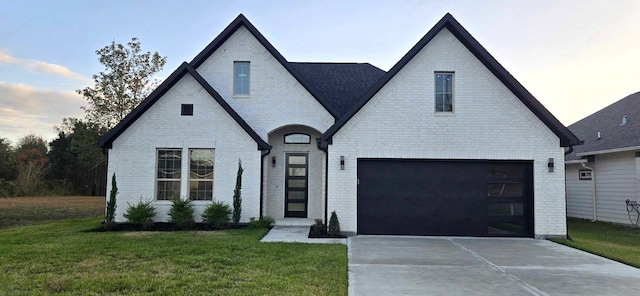 view of front of house with brick siding, driveway, and a front lawn
