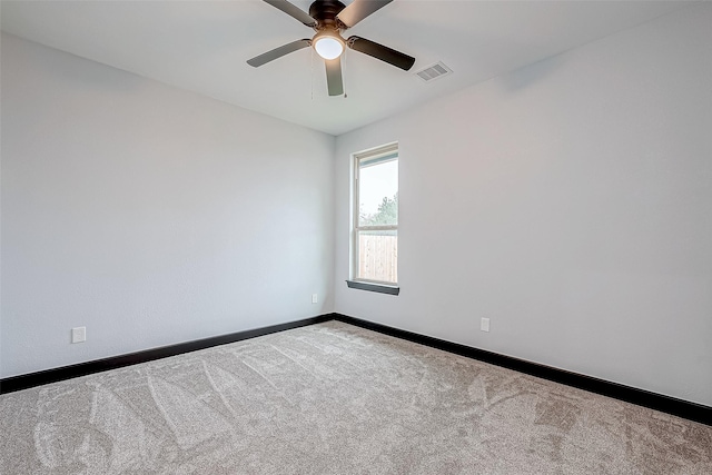 carpeted empty room featuring baseboards, ceiling fan, and visible vents