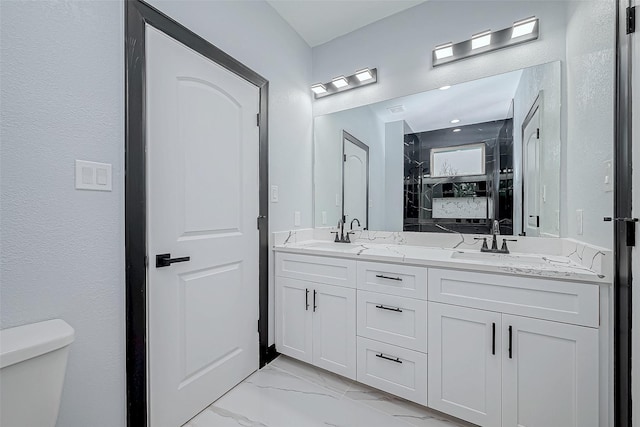 full bath with a shower stall, marble finish floor, double vanity, toilet, and a sink