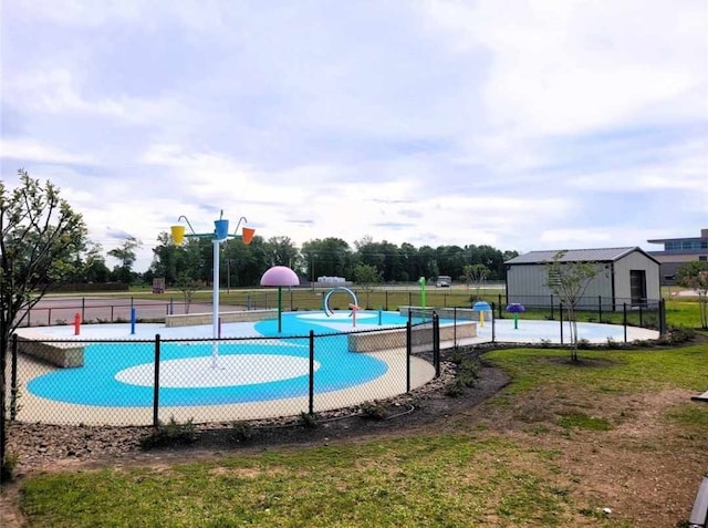 view of pool with a lawn, community basketball court, and fence