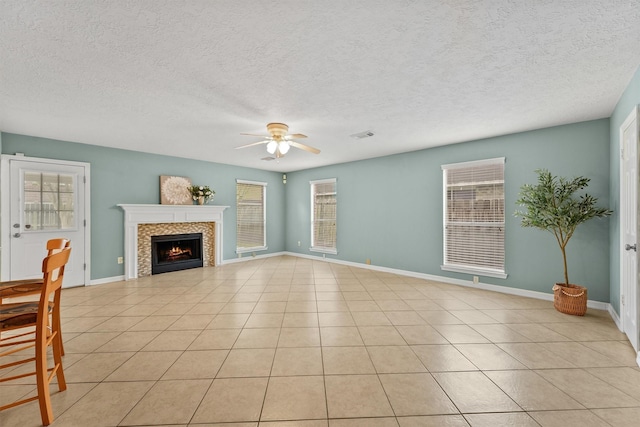 1231 Kings Creek Trl, Missouri City, TX 77459 - unfurnished living room featuring a fireplace, light tile patterned floors, baseboards, and a ceiling fan