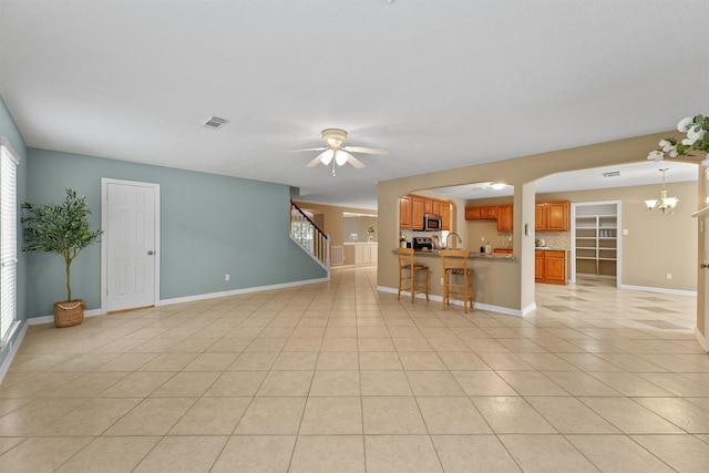 1231 Kings Creek Trl, Missouri City, TX 77459 - unfurnished living room with baseboards, light tile patterned floors, stairs, visible vents, and ceiling fan with notable chandelier