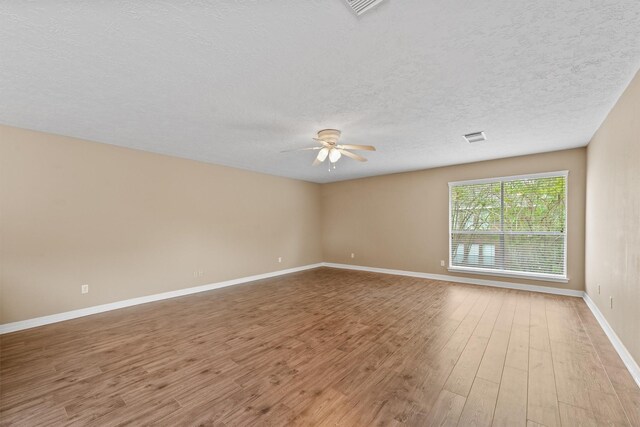 1231 Kings Creek Trl, Missouri City, TX 77459 - empty room featuring a textured ceiling, wood finished floors, ceiling fan, and baseboards