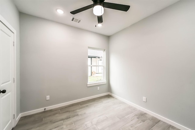 unfurnished room featuring baseboards, visible vents, light wood-style floors, and a ceiling fan