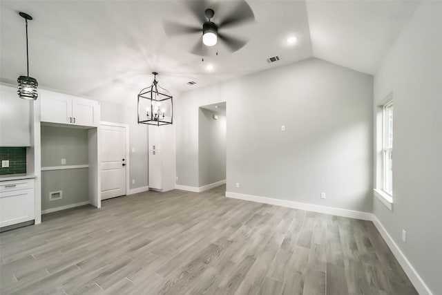 unfurnished living room featuring baseboards, visible vents, lofted ceiling, and light wood-type flooring