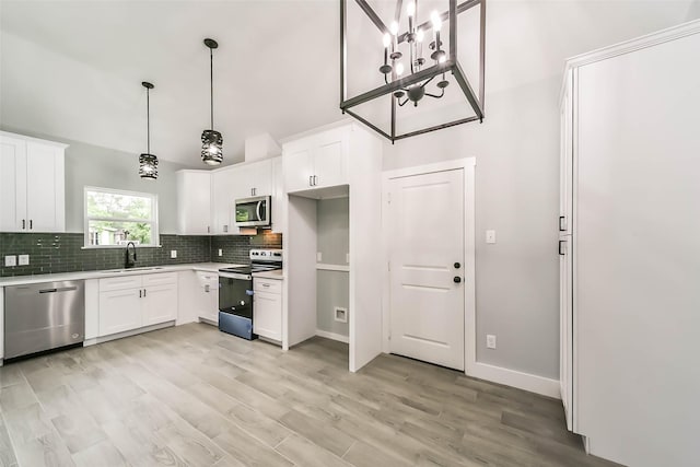 kitchen featuring light countertops, backsplash, a sink, white cabinets, and appliances with stainless steel finishes