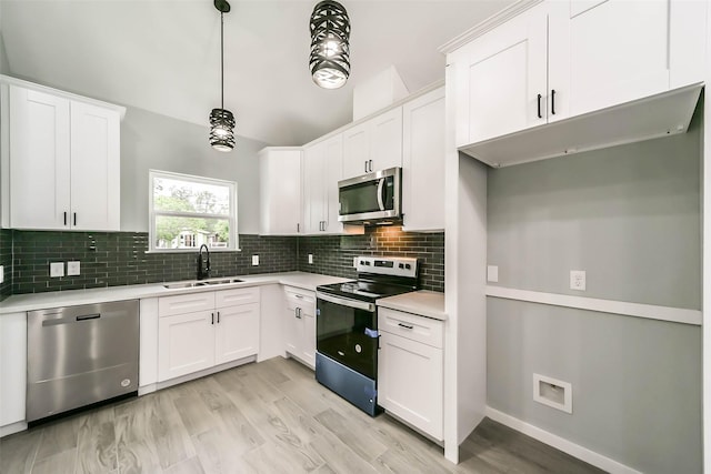 kitchen with light countertops, a sink, tasteful backsplash, and appliances with stainless steel finishes