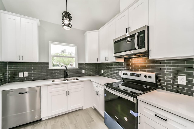 kitchen featuring white cabinetry, light countertops, tasteful backsplash, a sink, and appliances with stainless steel finishes