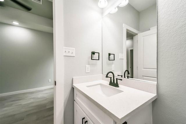 bathroom with baseboards, wood finished floors, and vanity